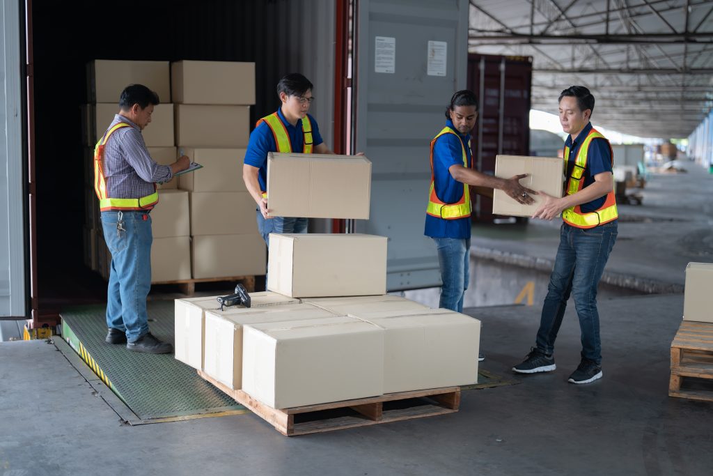 Trabajadores de logística moviendo cajas en almacén como parte de los servicios de transporte Madrid Este